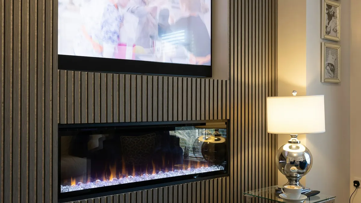 LG Fernseher an einer Wohnzimmerwand mit eingeschaltetem Bildschirm