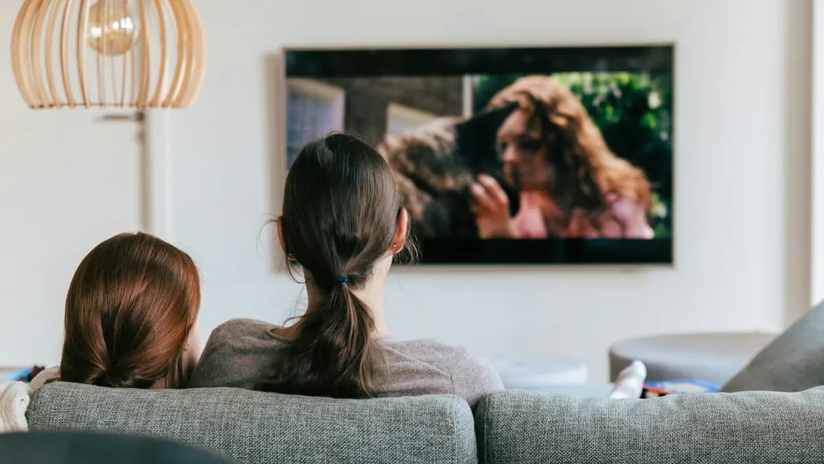 Familie schaut entspannt IPTV über Smart-TV und Streaming-Stick im Wohnzimmer