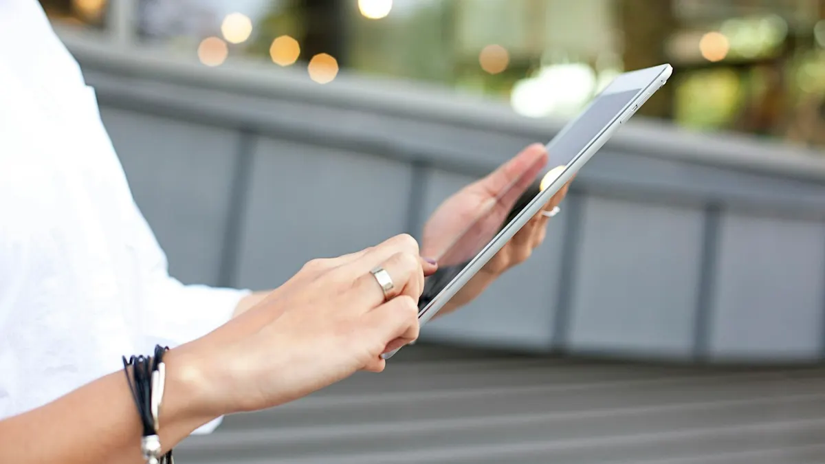 Person liest aufmerksam Vertragsbedingungen eines IPTV Abonnements auf einem Tablet